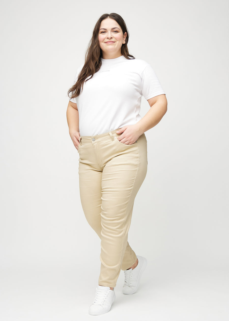 Fuldt billede af en plus-size model i beige slim jeans.