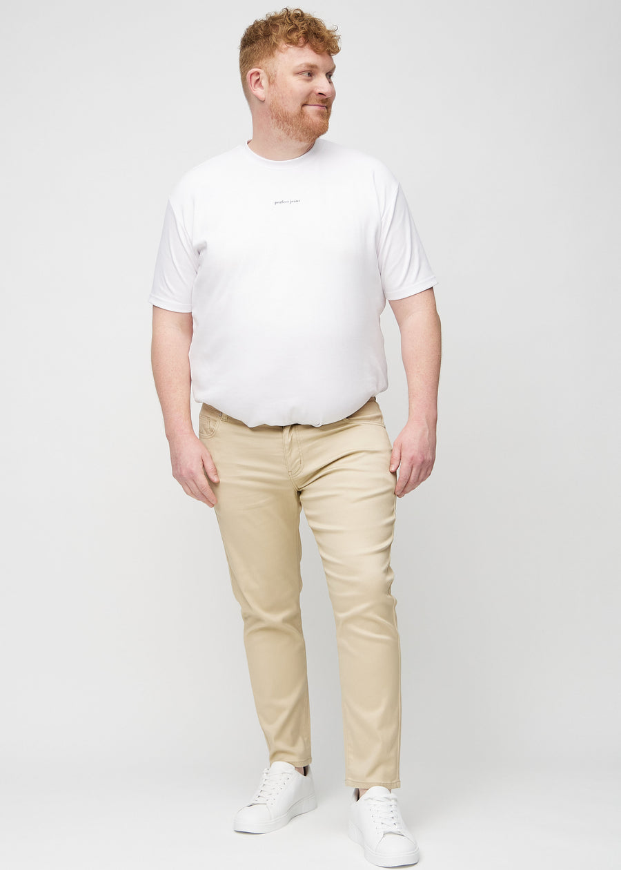 Fuldt billede af en plus-size model i beige slim jeans.