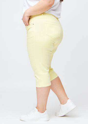 Lysegule slim capris i farven Lemonades – set fra siden på en plus-size model.