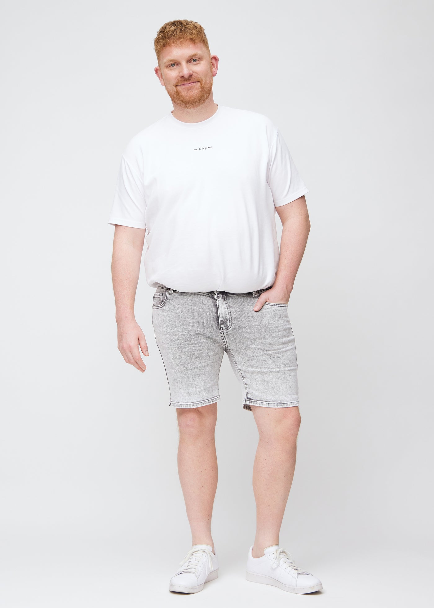 Fuldt billede af en plus-size model i lysegrå denim regular middle shorts.