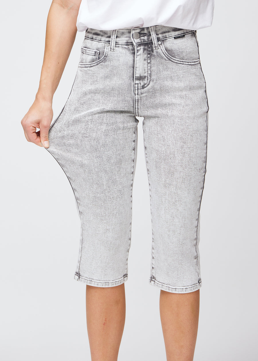 Model strækker caprisene ved låret for at vise stretch.