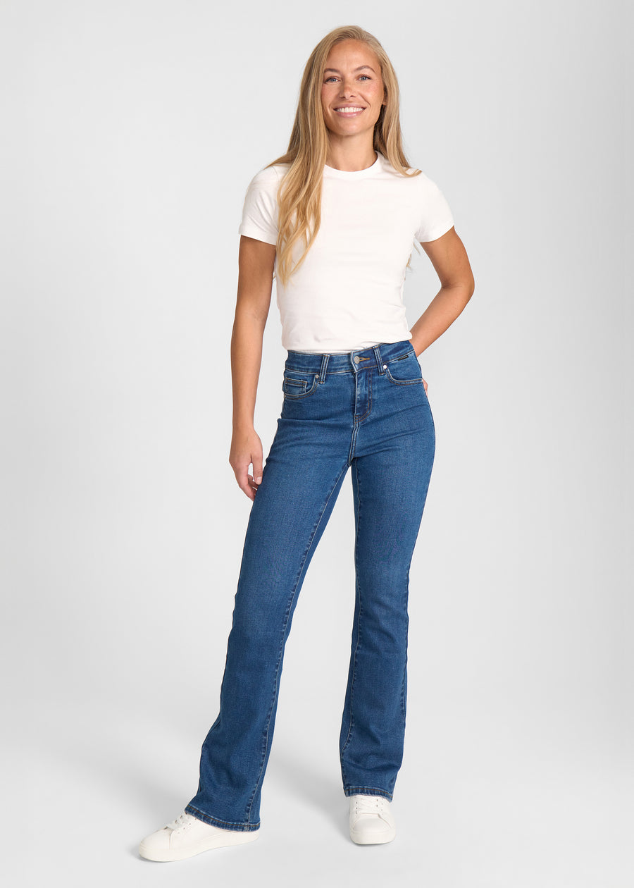 Fuldt billede af model i mørkeblå denim bootcut jeans.