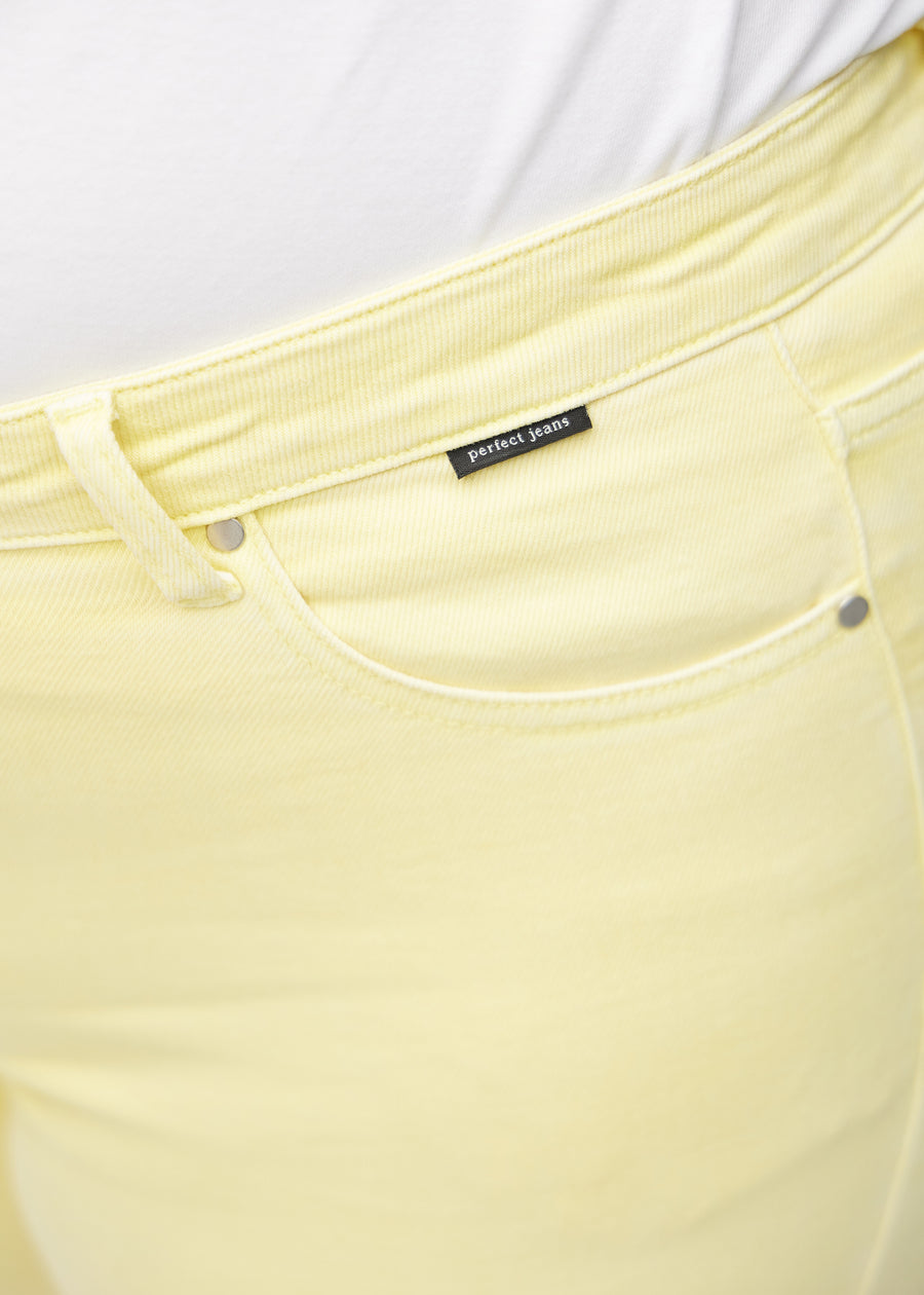 Forlommen på et par lysegule regular capris, hvor man kan se logoet på en plus-size model.