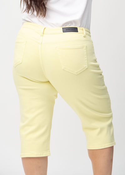 Lysegule regular capris set bagfra tæt på en plus-size model for at vise detaljer.