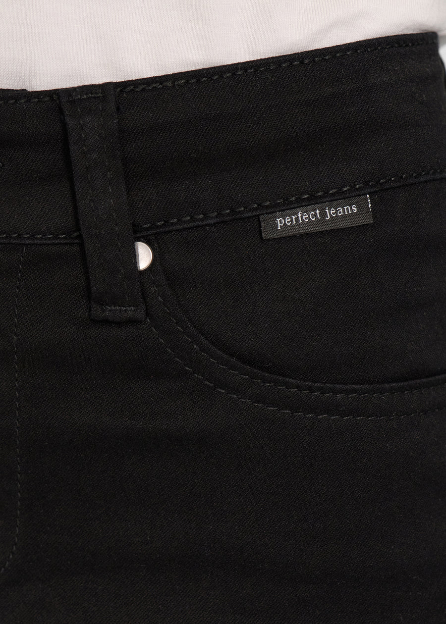 Nærbillede af sort jeansmateriale med Perfect Jeans logoetiket ved forlommekanten.