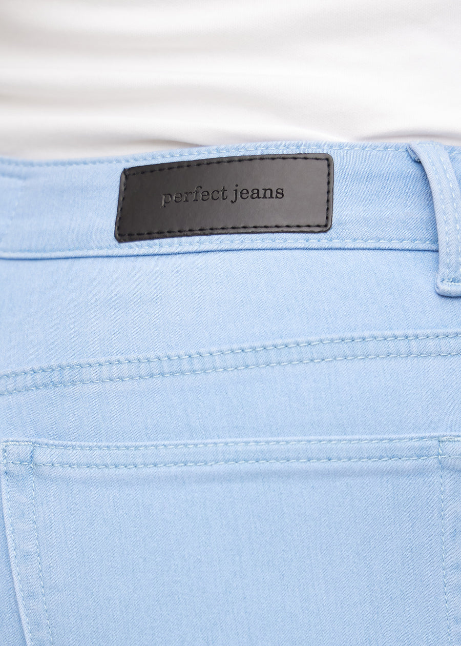 Nærbillede af lyseblåt jeansmateriale med Perfect Jeans læderpatch bagpå i taljen, på en plus-size model.