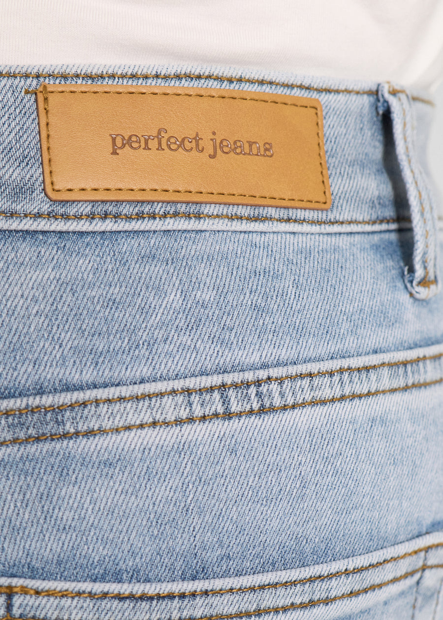 Nærbillede af lyseblå denim med Perfect Jeans læderpatch bagpå i taljen, på en plus-size model.