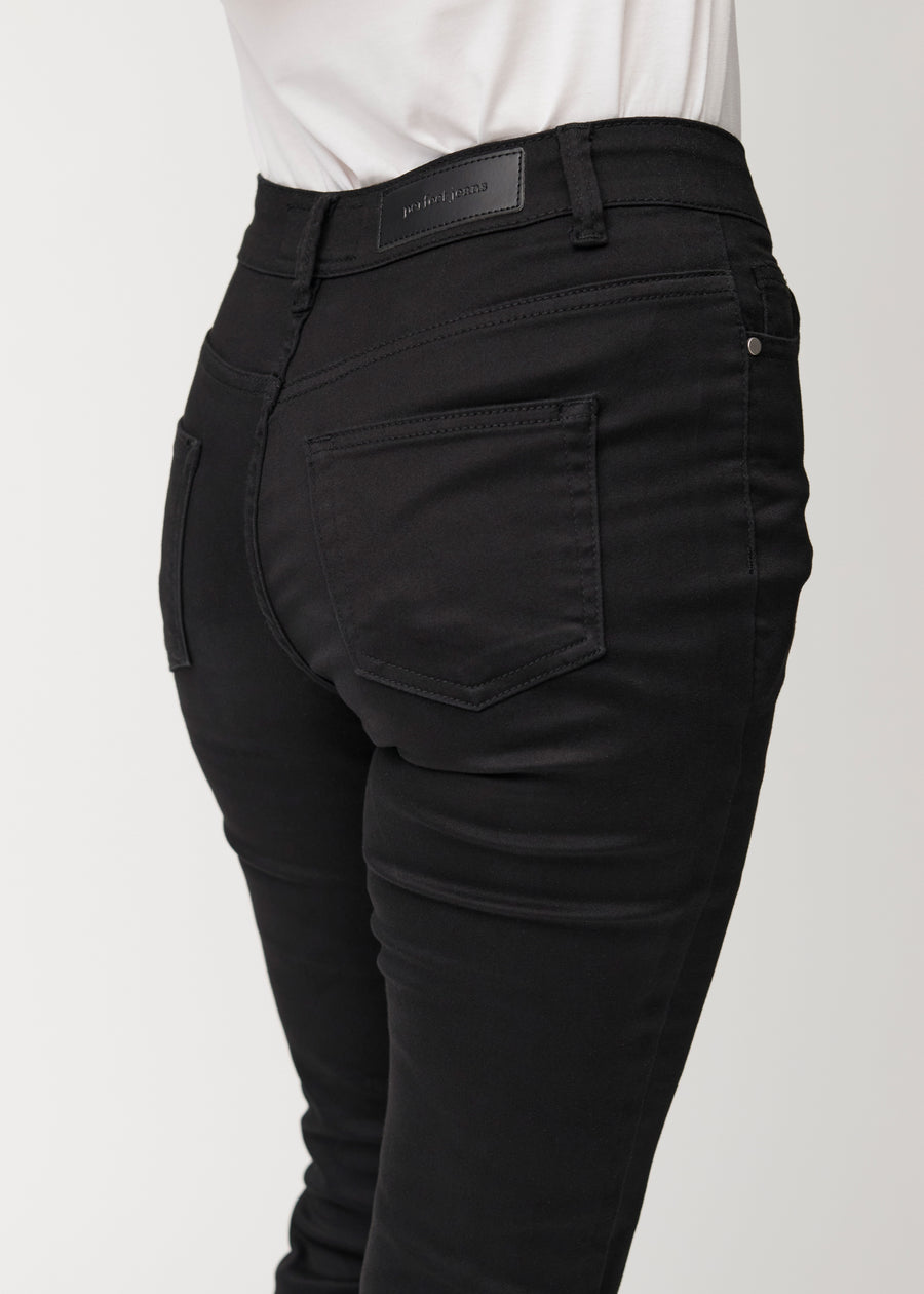 Sorte mid-rise bootcut jeans set bagfra tæt på for at vise detaljer.
