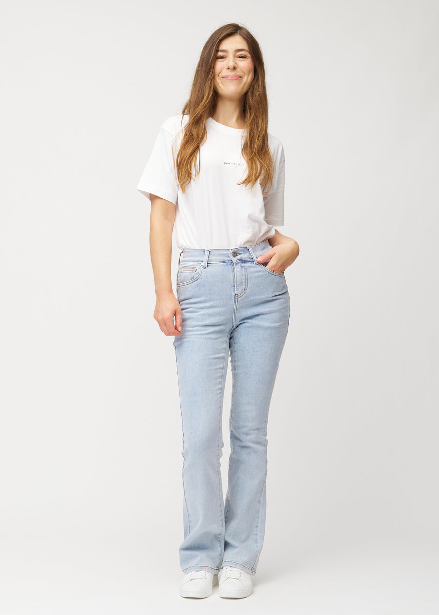 Light blue mid-rise bootcut jeans in Waves. Full-length view of a model wearing the jeans.