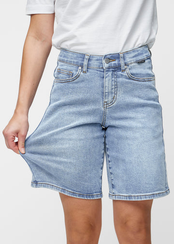 Loose, light blue denim shorts in the colour Waves, sitting at the hips and falling loosely over the thighs to just above the knee, seen from the front.
