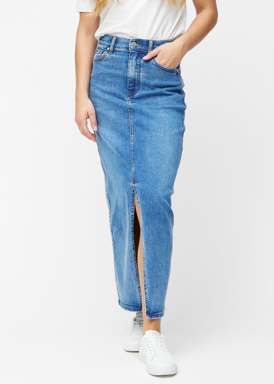 Lang, klassisk blå denimnederdel i farven Rivers med regulær pasform, der sidder tæt til hoften og falder lige ned til anklerne, med slids foran der starter lige under knæet, set forfra.