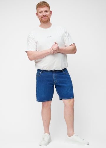 Full image of a plus-size model wearing dark blue denim shorts for men in the colour Oceans with a regular fit.
