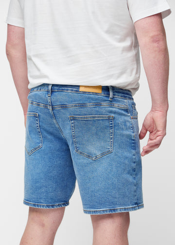 Blue denim shorts for men in the colour Rivers seen from the back close up on a plus-size model to show fit and details.