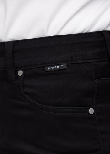 Close-up of black jeans material with the Perfect Jeans logo label at the edge of the front pocket.