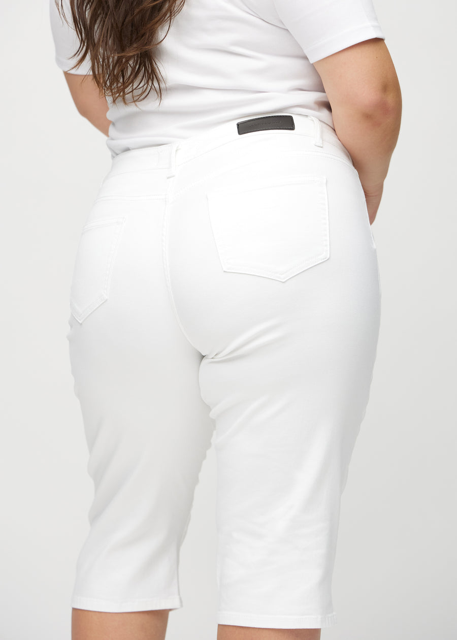White regular capris seen from the back in close-up on a plus-size model to show details.