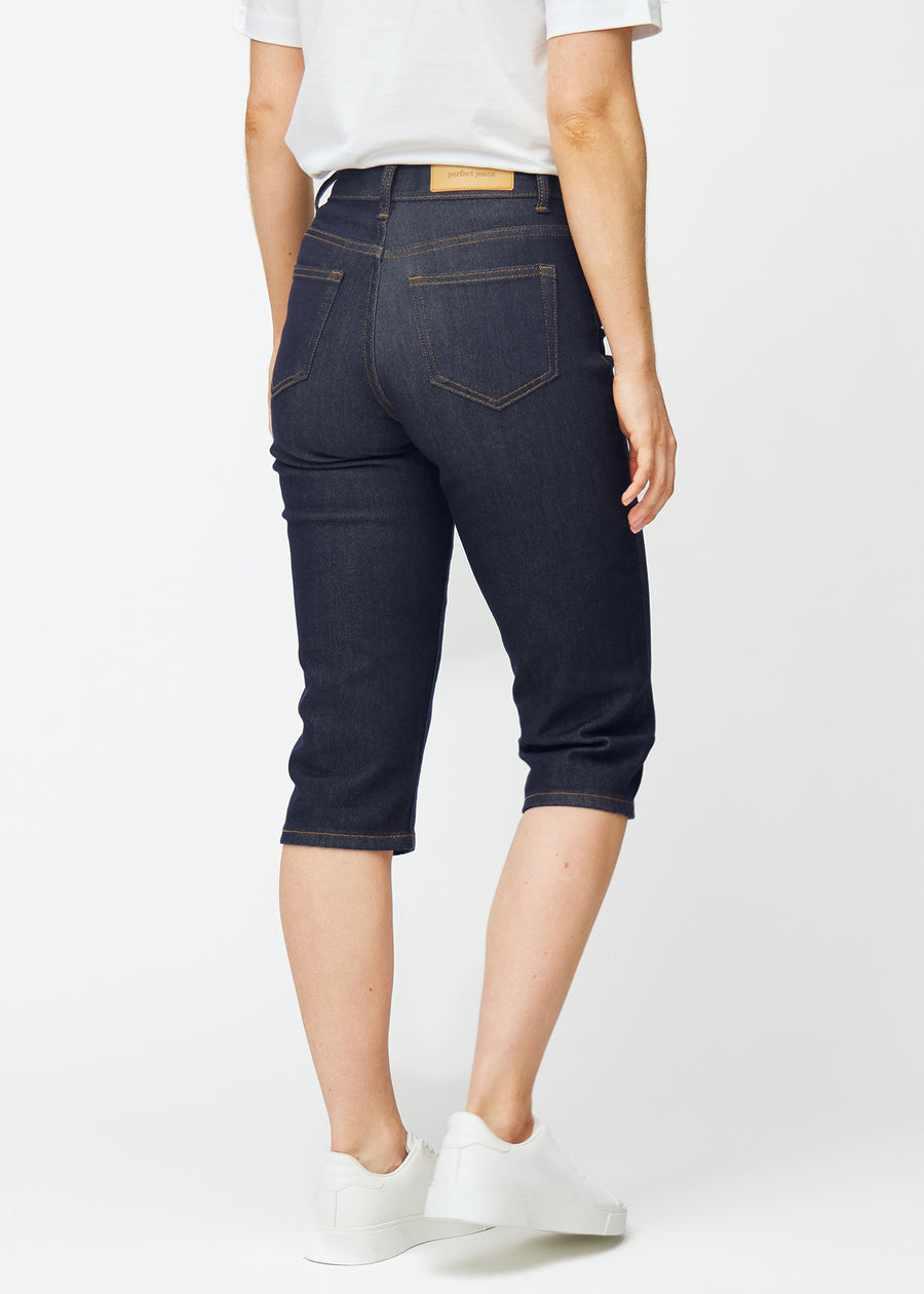 Deep dark blue denim capris for women in the colour Midnights seen from the back, showing the length below the knee.