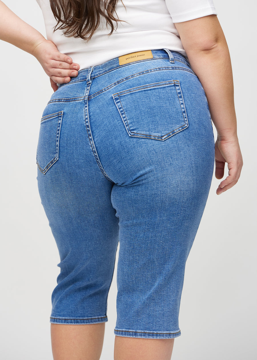 Denim regular capris seen from the back close up on a plus-size model to show details.