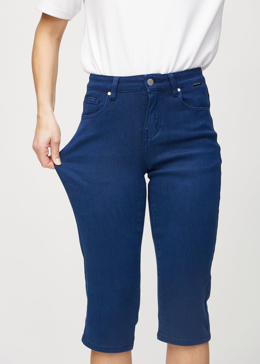 The model stretches the capris at the thigh to show the stretch.