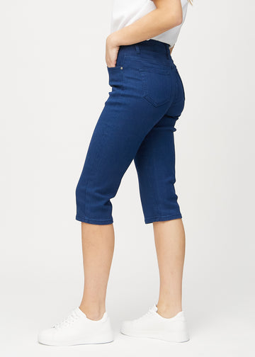 Dark blue regular capris seen from the side on a model.