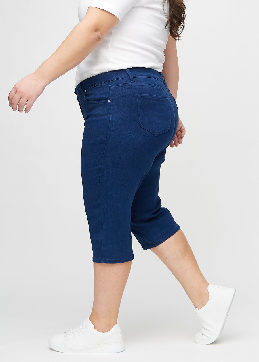 Dark blue regular capris seen from the side on a plus-size model.