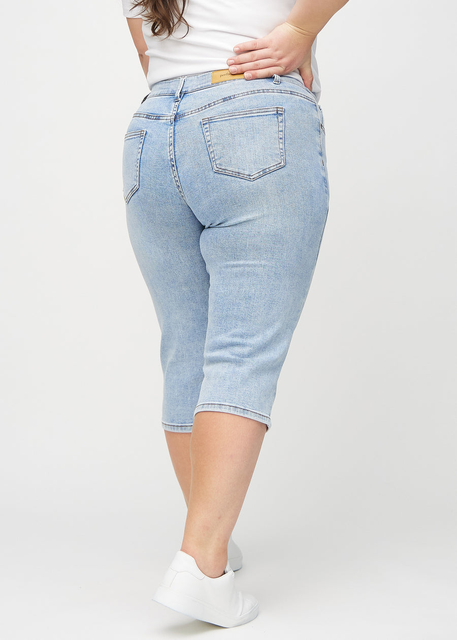 Light denim regular capris seen from the back on a plus-size model, so the entire product can be seen.