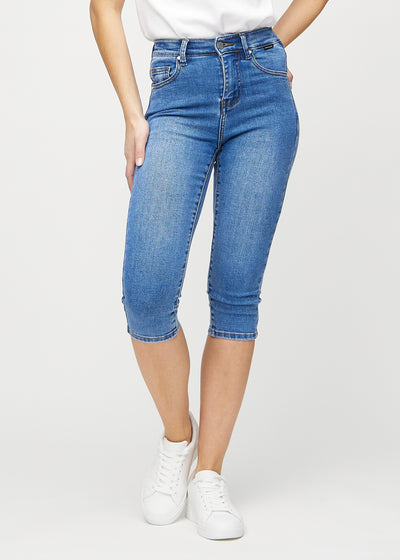 Skinny capris for women in blue denim, color Rivers. Front view on a model, showing the close-fitting legs ending just below the knee.