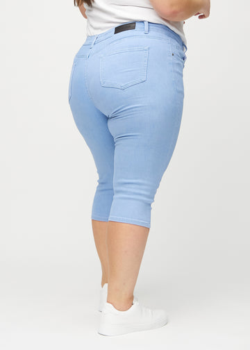 Skinny capris for women in light blue fabric, color Skies. Back view on a plus-size model, showing the fit and back pockets.