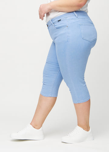 Skinny capris for women in light blue fabric, color Skies. Side view on a plus-size model, showing the fitted cut.