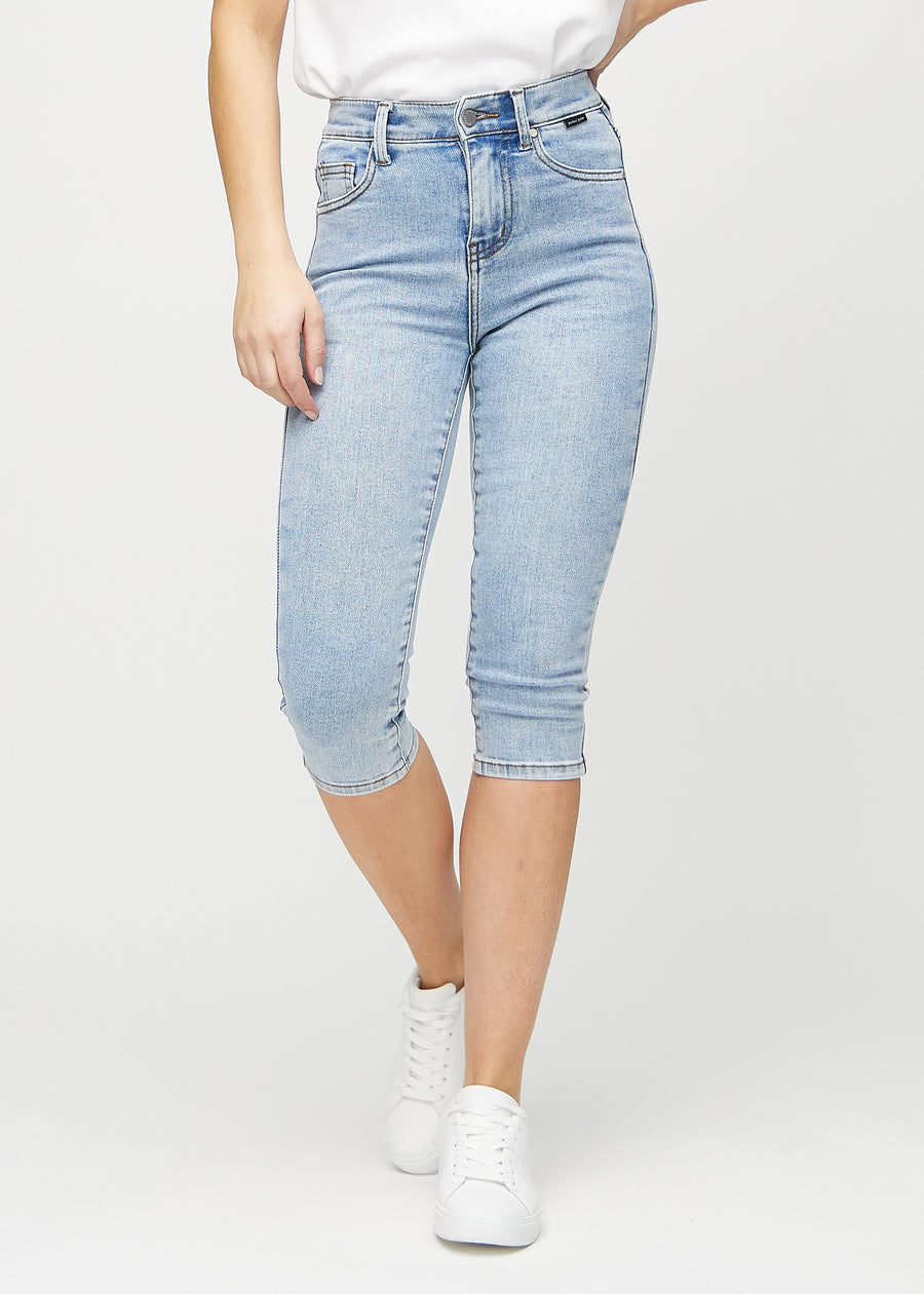 Skinny capris for women in light blue denim, color Waves. Front view on a model, showing the close-fitting legs ending just below the knee.