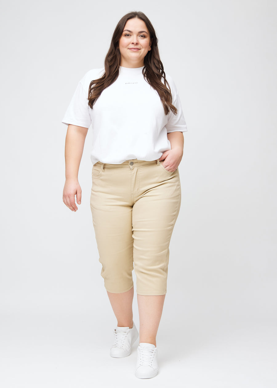 Slim capris for women in beige jeans fabric, color Gazelles. Full-length view of a plus-size model wearing slim capris.