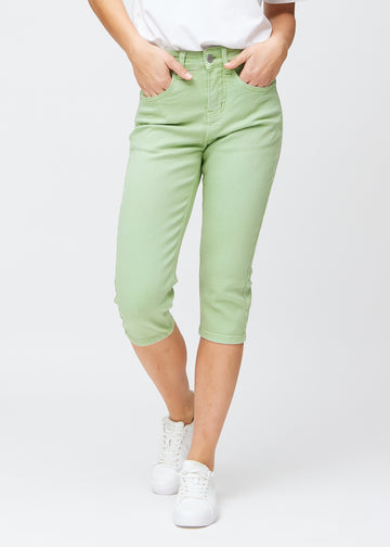 Slim capris for women in pastel light green jeans fabric, color Mints. Front view on a model, showing the fitted cut ending just below the knee.