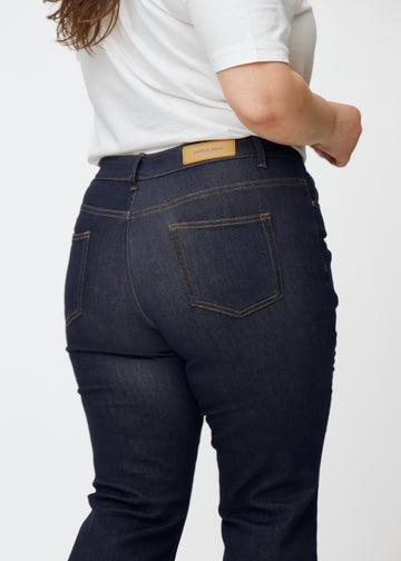 Deep dark blue denim jeans for women in the color Midnights seen from the back in close-up on a plus-size model.
