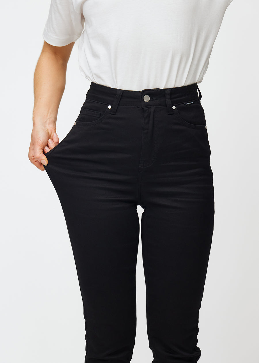 The model stretches the jeans at the thigh to show the stretch.