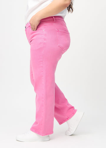 Loose jeans for women in light pink, color Flamingos. Side view on a plus-size model, showing the loose fit.