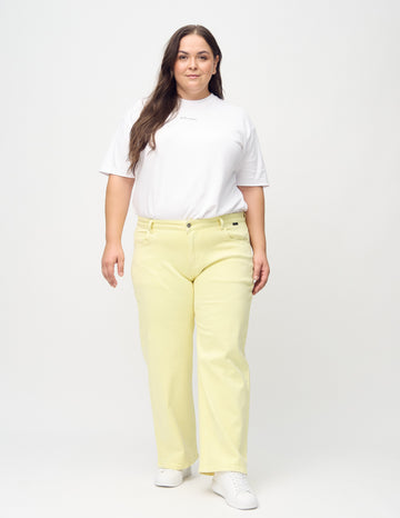 Loose jeans for women in light yellow, color Lemonades. Full-length view of a plus-size model wearing the loose-fit jeans.