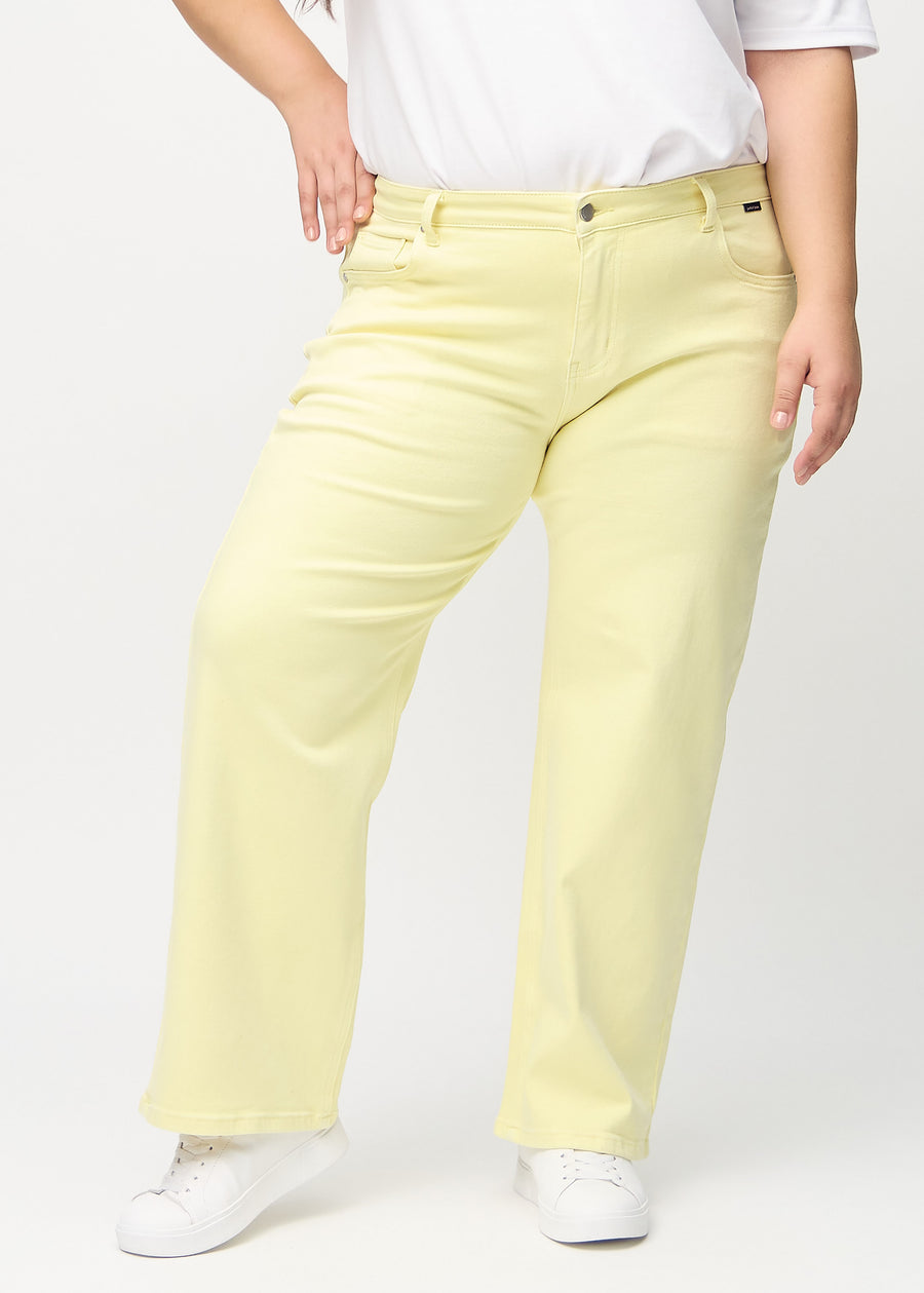 Loose jeans for women in light yellow, color Lemonades. Front view on a plus-size model, showing the roomy, wide-leg fit.