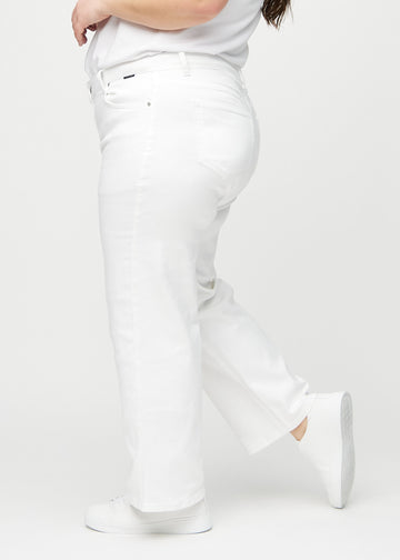 White loose jeans seen from the side on a plus-size model.