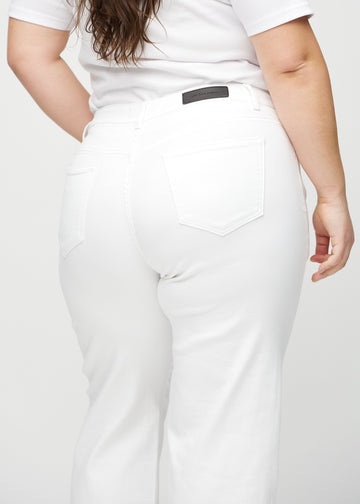 White loose jeans seen from the back close up on a plus-size model to show details.