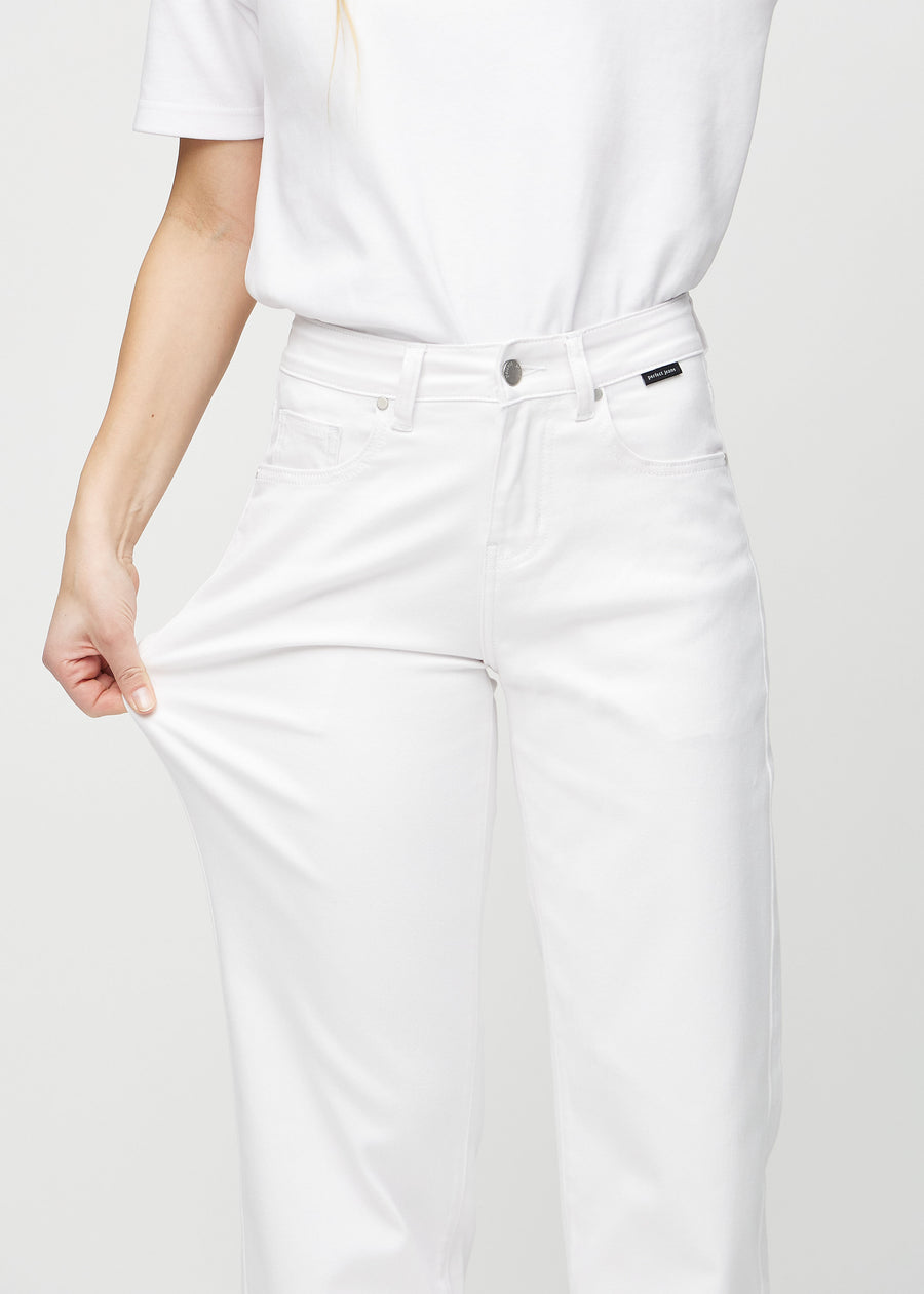 The model stretches the jeans at the thigh to show the stretch.