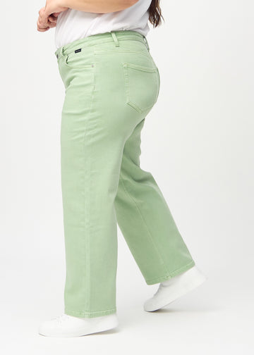 Loose jeans for women in light green, color Mints. Side view on a plus-size model, showing the loose fit.