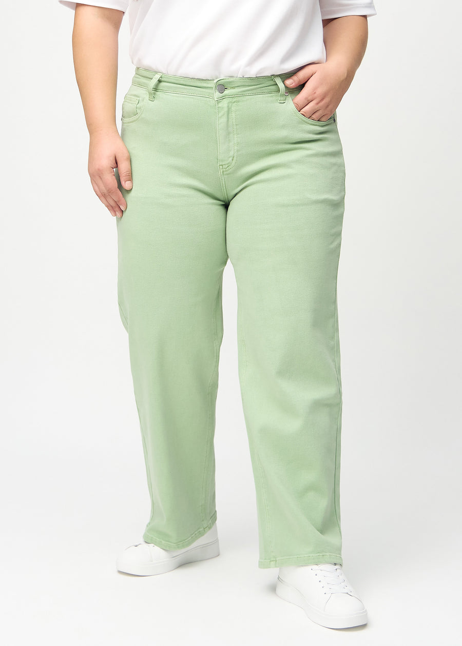 Loose jeans for women in light green, color Mints. Front view on a plus-size model, showing the roomy, wide-leg fit.