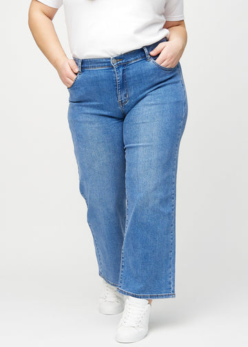 Denim loose jeans, model name Rivers, which is loose-fitting with plenty of width in the legs on a plus-size model, seen from the front.