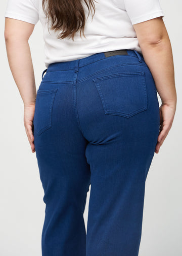 Dark blue loose jeans seen from the back close up on a plus-size model to show details.