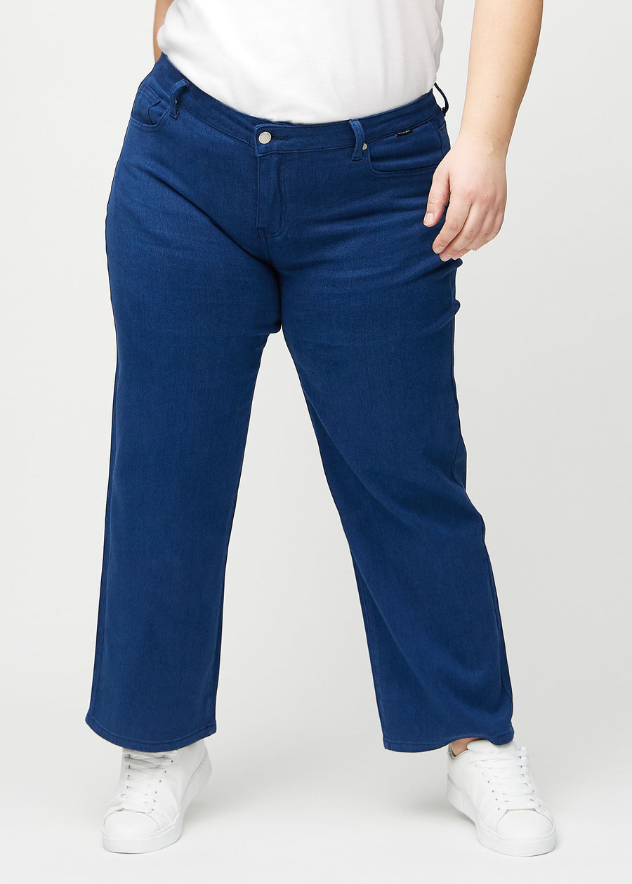 Dark blue loose jeans, model name Royals, which has a loose fit with plenty of width in the legs on a plus-size model, seen from the front.
