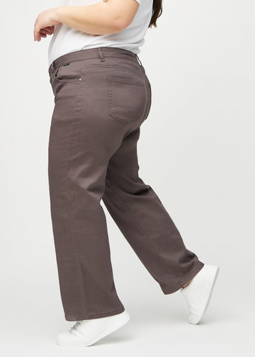 Grey-brown loose jeans seen from the side on a plus-size model.