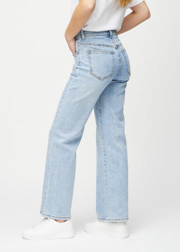 Loose jeans for women in light blue, color Waves. Side view on a model, showing the loose fit.