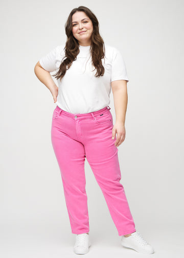 Regular jeans for women in light pink, color Flamingos. Full-length view of a plus-size model wearing the jeans.