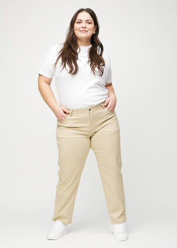 Regular jeans for women in beige, color Gazelles. Full-length view of a plus-size model wearing the jeans.