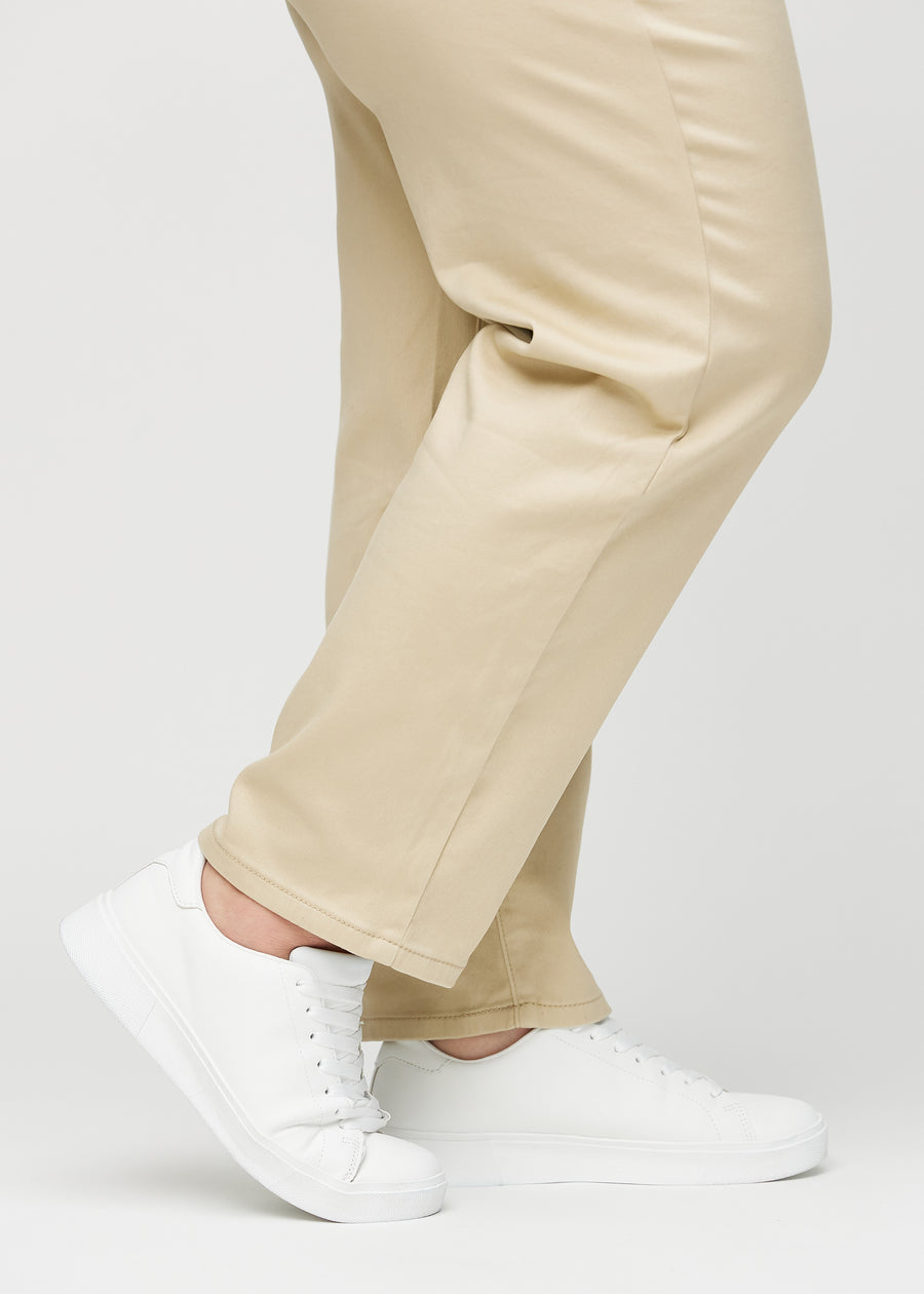 Regular jeans for women in beige, color Gazelles. Close-up at the ankles on a plus-size model, showing the straight leg openings.