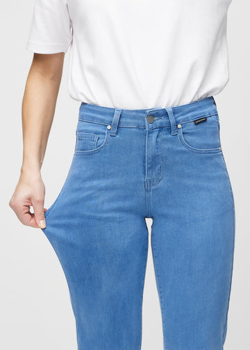 Regular jeans for women in blue, color Geraniums. A model stretches the fabric at the thigh to show its stretch.